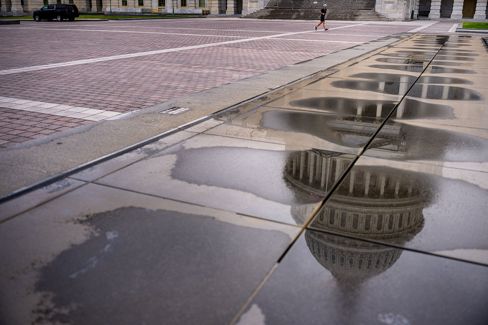 The Capitol dome reflected in water on pavement
