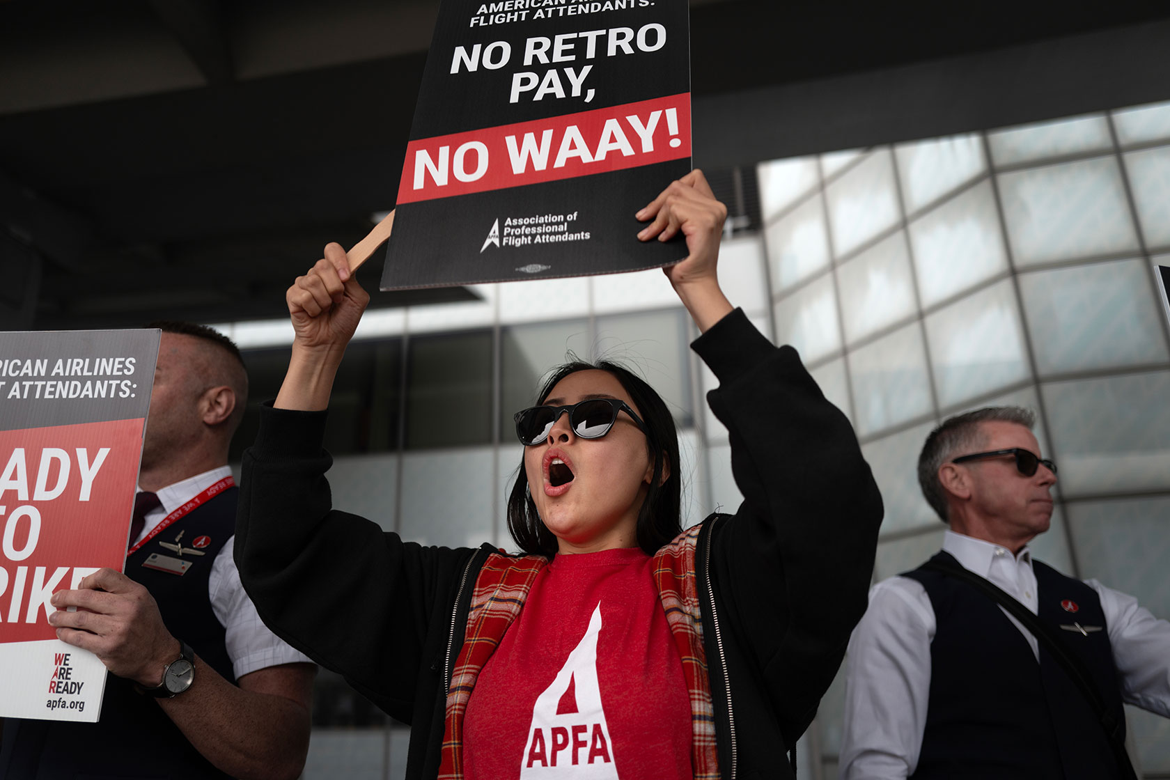 Woman holding up sign demanding retro pay